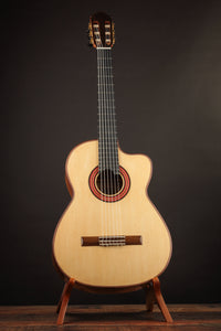 Classical guitar on a stand against a dark background