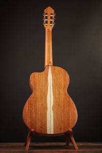 Classical guitar on a stand against a dark background, from the back