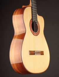 Classical guitar with a dark background, from the side.