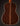 Back view of a classical acoustic guitar on a dark background