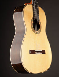 Classical guitar on a black background, from the side