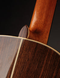 Close-up of the heel on a classical guitar with a dark background
