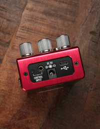 Red effects pedal on wood background