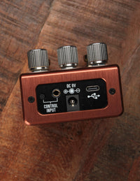 Brown effects pedal on wood background