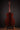 Acoustic guitar on a stand against a dark background