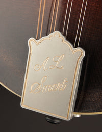 Close-up of a mandolin tailpiece with AL Smart engraved on the cover