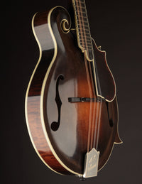 Close-up of a mandolin with a dark brown finish on a black background