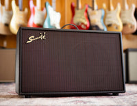 Black Swart amplifier with guitars in the background