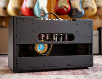 Black Swart amplifier with guitars in the background