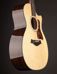 Side view of Taylor acoustic guitar on a dark background