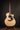 Taylor acoustic guitar on a stand against a dark background 