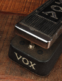 Close-up of a VOX guitar pedal on a wooden surface