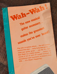 Vox Wah-Wah pedal packaging with promotional text on a wooden surface