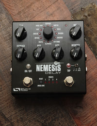 A black Source Audio One Series Nemesis Delay pedal with multiple control knobs and switches, featuring a brushed anodized aluminum housing.